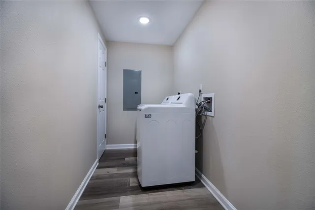 a utility room with wooden floor washer and dryer