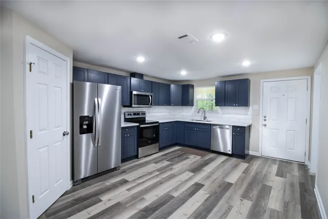 a large kitchen with a large refrigerator and wooden cabinets