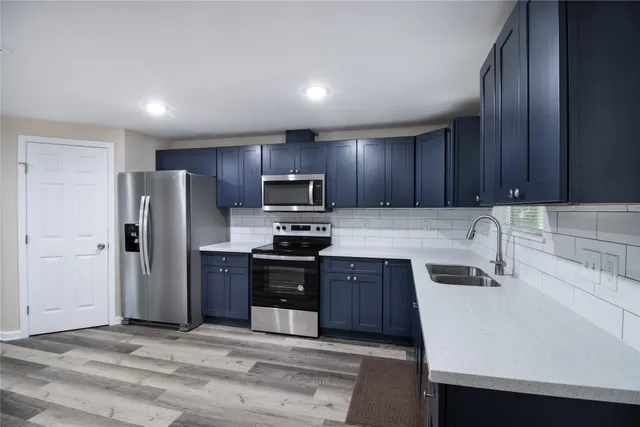 a kitchen with refrigerator cabinets and wooden floor