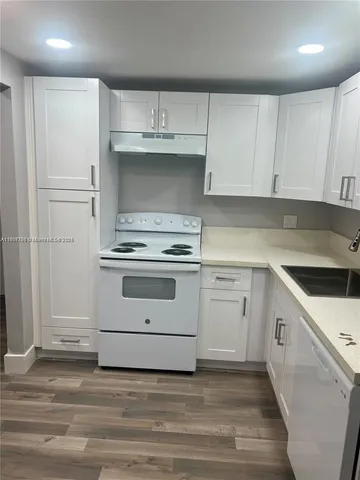 a kitchen with white cabinets and white appliances