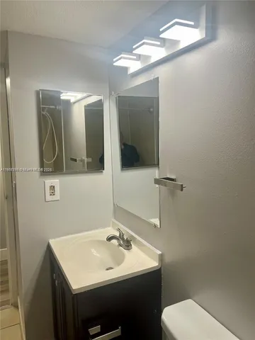 a bathroom with a toilet sink and mirror