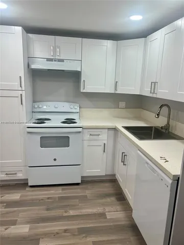 a kitchen with cabinets appliances a sink and a stove