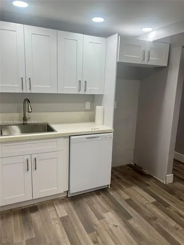 a kitchen with a sink cabinets and wooden floor