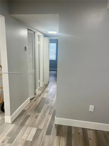 a view of hallway with wooden floor