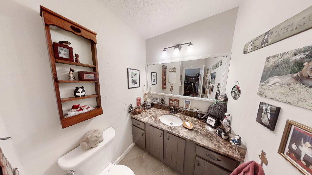 59 Route 6A, Unit 323 Orleans, MA 02653 - Photo 6 of 23 a bathroom with a granite countertop sink mirror vanity and toilet