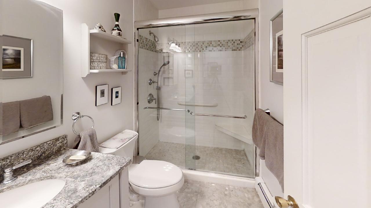 59 Route 6A, Unit 323 Orleans, MA 02653 - Photo 10 of 23 a bathroom with a granite countertop sink toilet and shower