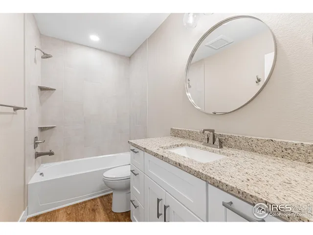 a bathroom with a granite countertop sink a toilet and a mirror