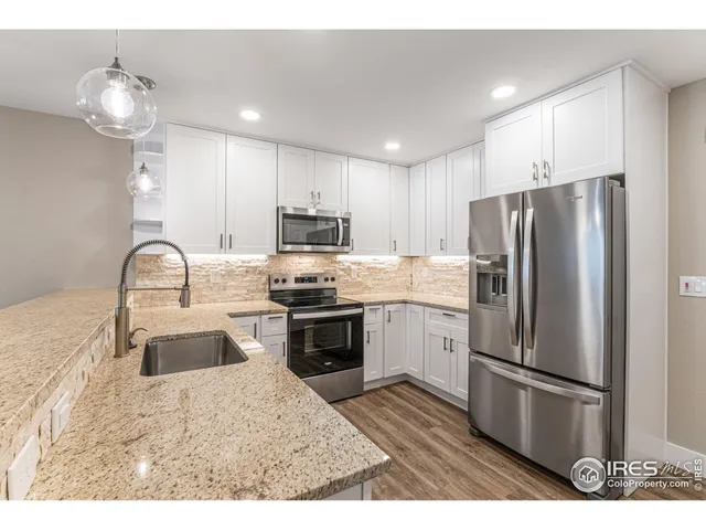a kitchen with a refrigerator a sink a stove and cabinets