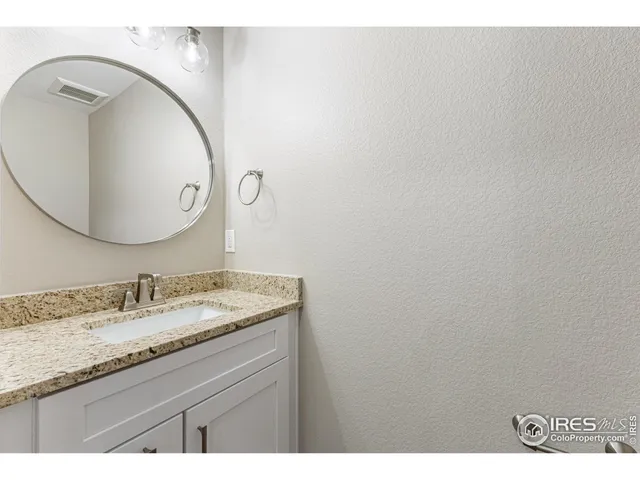 a bathroom with a granite countertop sink and mirror