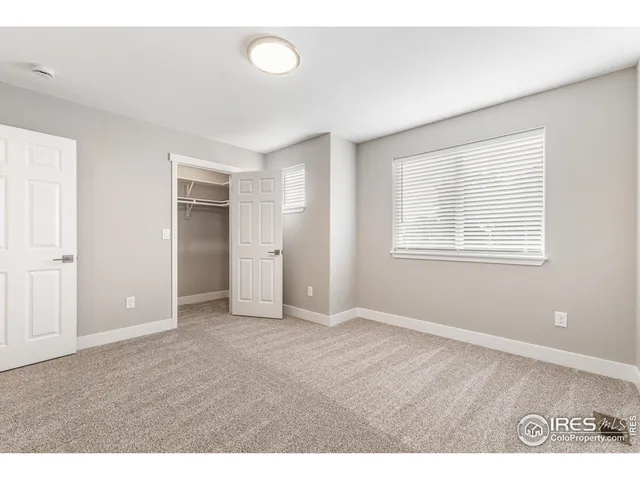 a view of an empty room with closet and a window