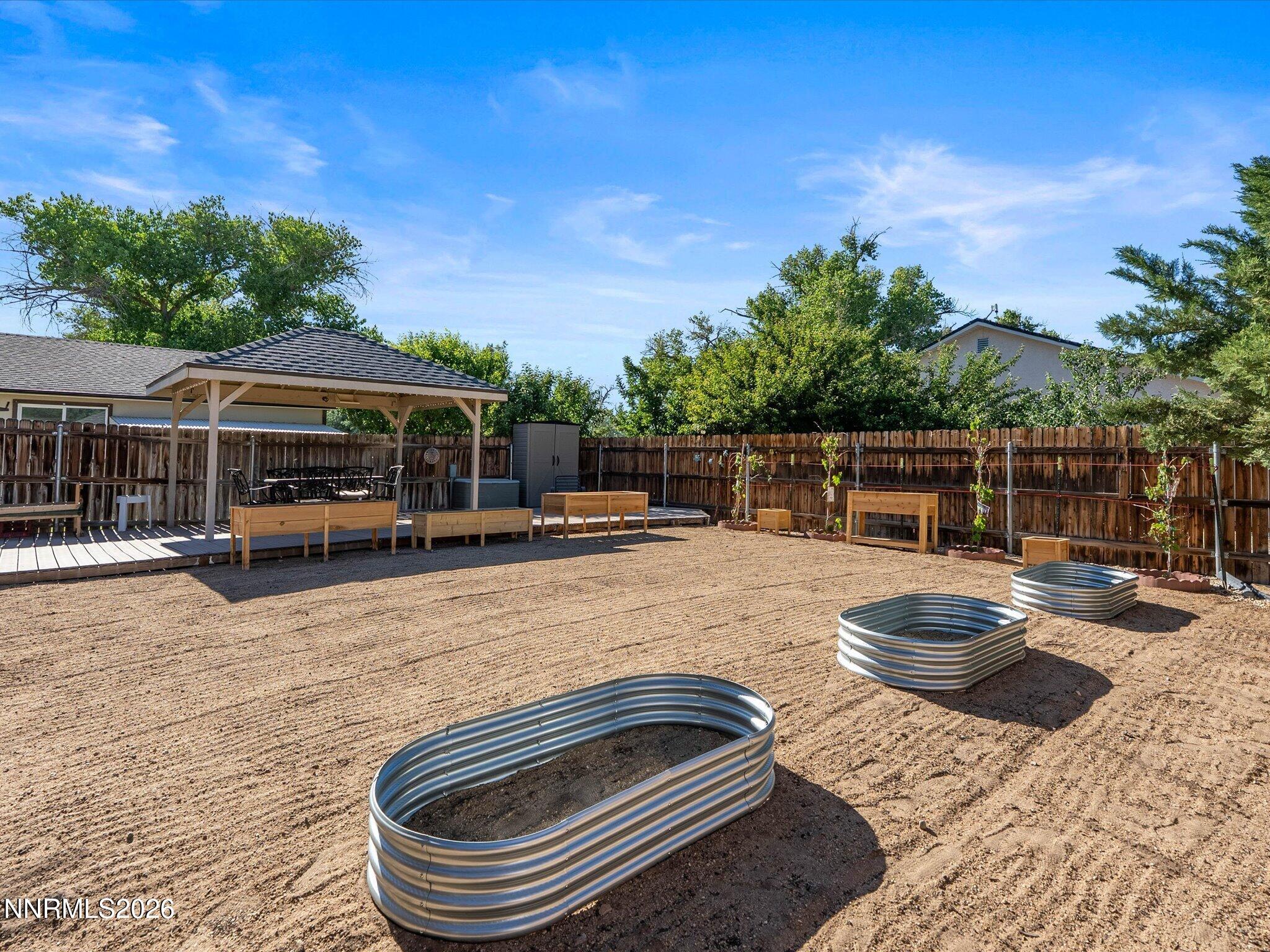 1080 Red Rock Road Fernley, NV 89408 - Photo 40 of 45 a backyard of a house with barbeque oven table and chairs