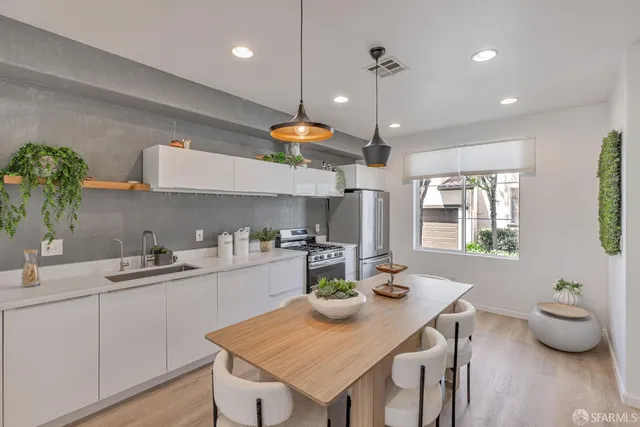 a kitchen with a sink a stove and chairs
