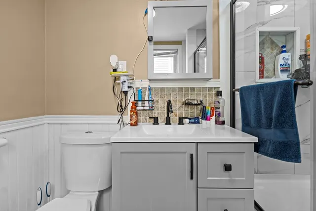 a bathroom with a sink vanity and toilet