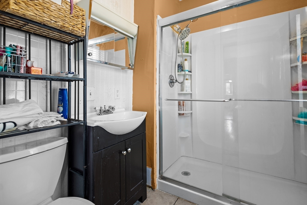 97 Warwick Street Woonsocket, RI 02895 - Photo 32 of 40 a bathroom with a granite countertop sink a toilet and shower