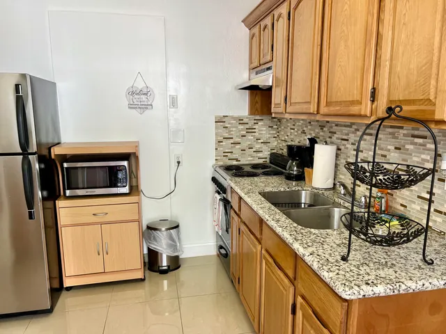 a kitchen with stainless steel appliances granite countertop a sink stove and refrigerator