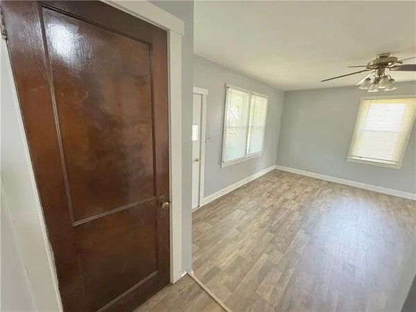 an empty room with wooden floor and windows