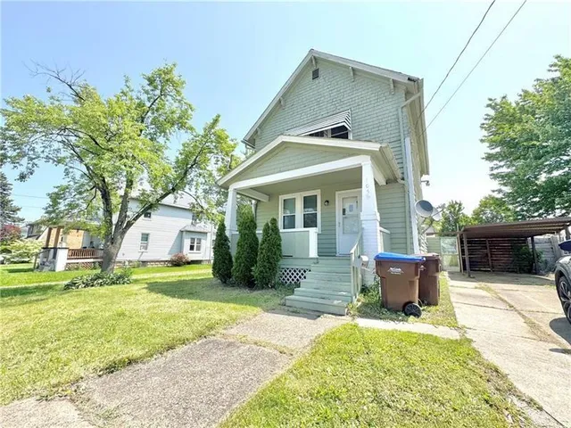 a front view of a house with a yard and trees