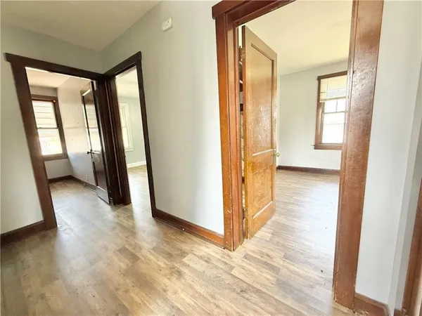 a view of a hallway with wooden floor and windows