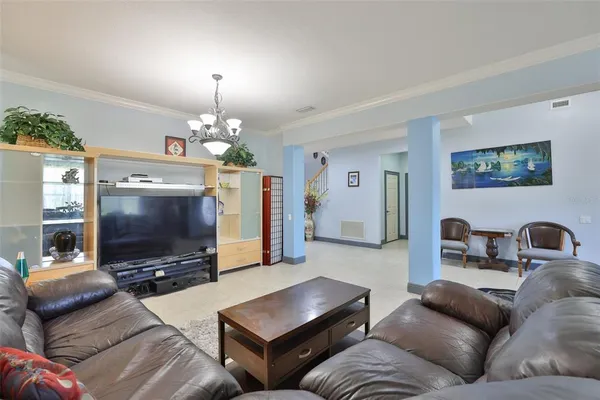 a living room with furniture a flat screen tv and kitchen view