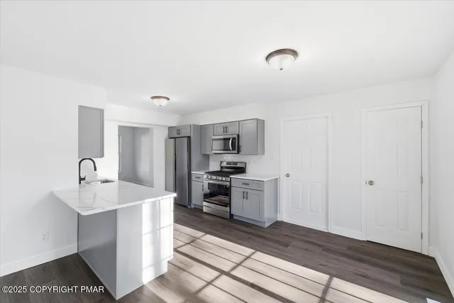 a large kitchen with kitchen island a sink stainless steel appliances and cabinets