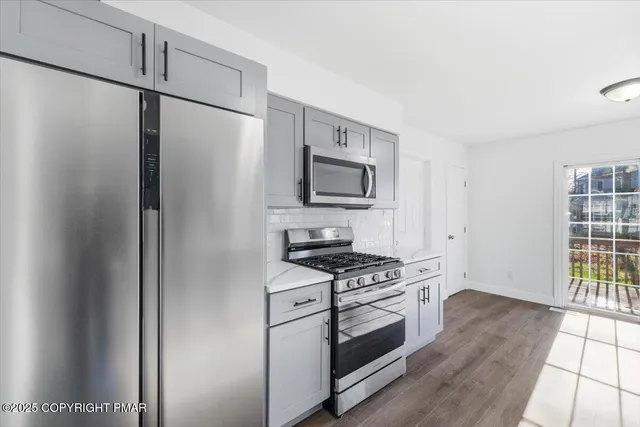 a kitchen with stainless steel appliances a refrigerator stove and microwave
