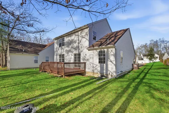 a view of a deck with a big yard potted plants and large tree