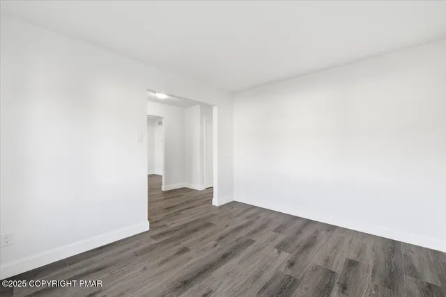 a view of an empty room with wooden floor