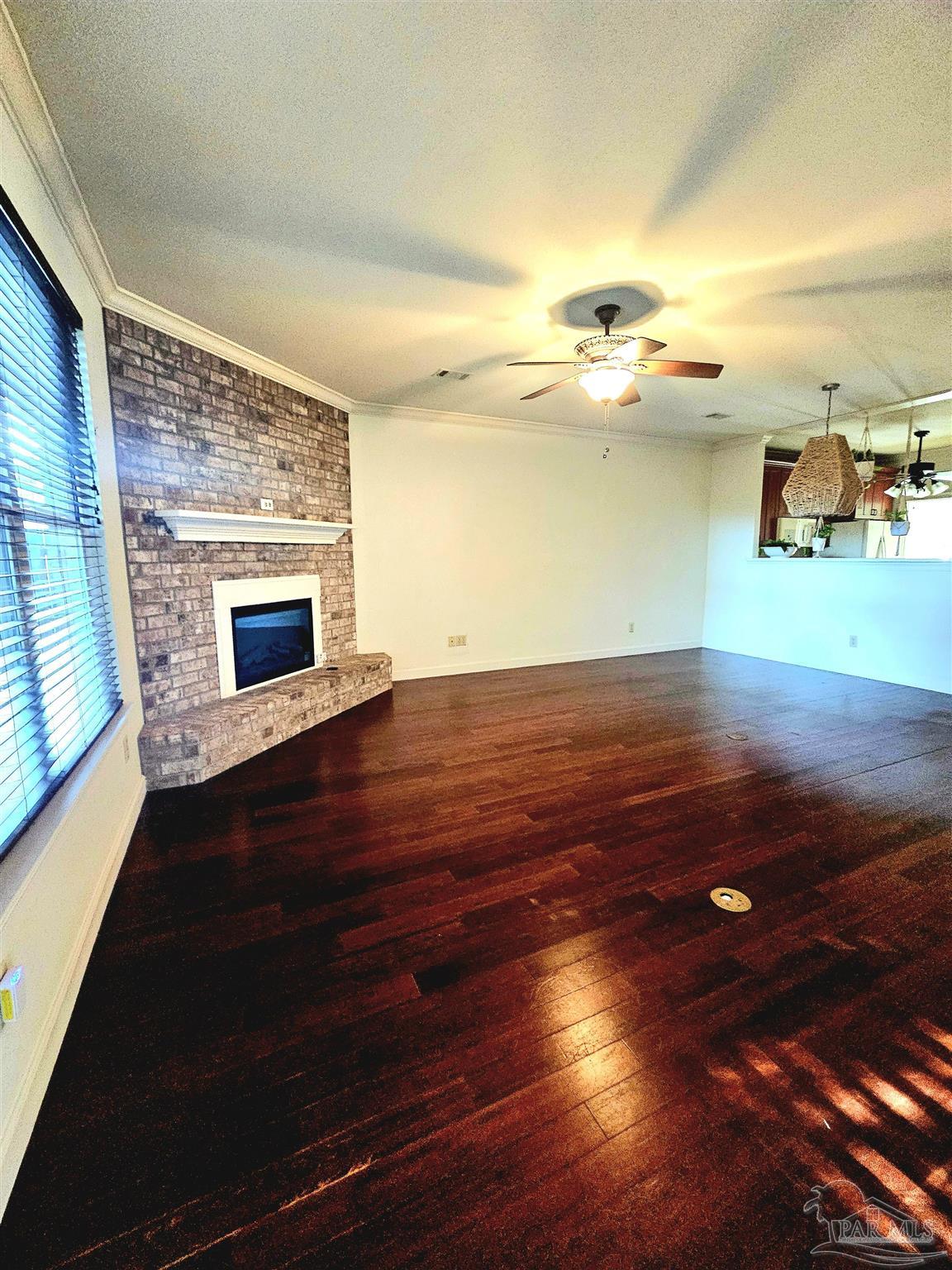 6148 The Oaks Lane, Unit B Pensacola, FL 32504 - Photo 11 of 20 an empty room with wooden floor fireplace and windows