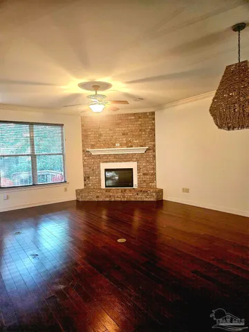 a view of empty room with wooden floor and fireplace