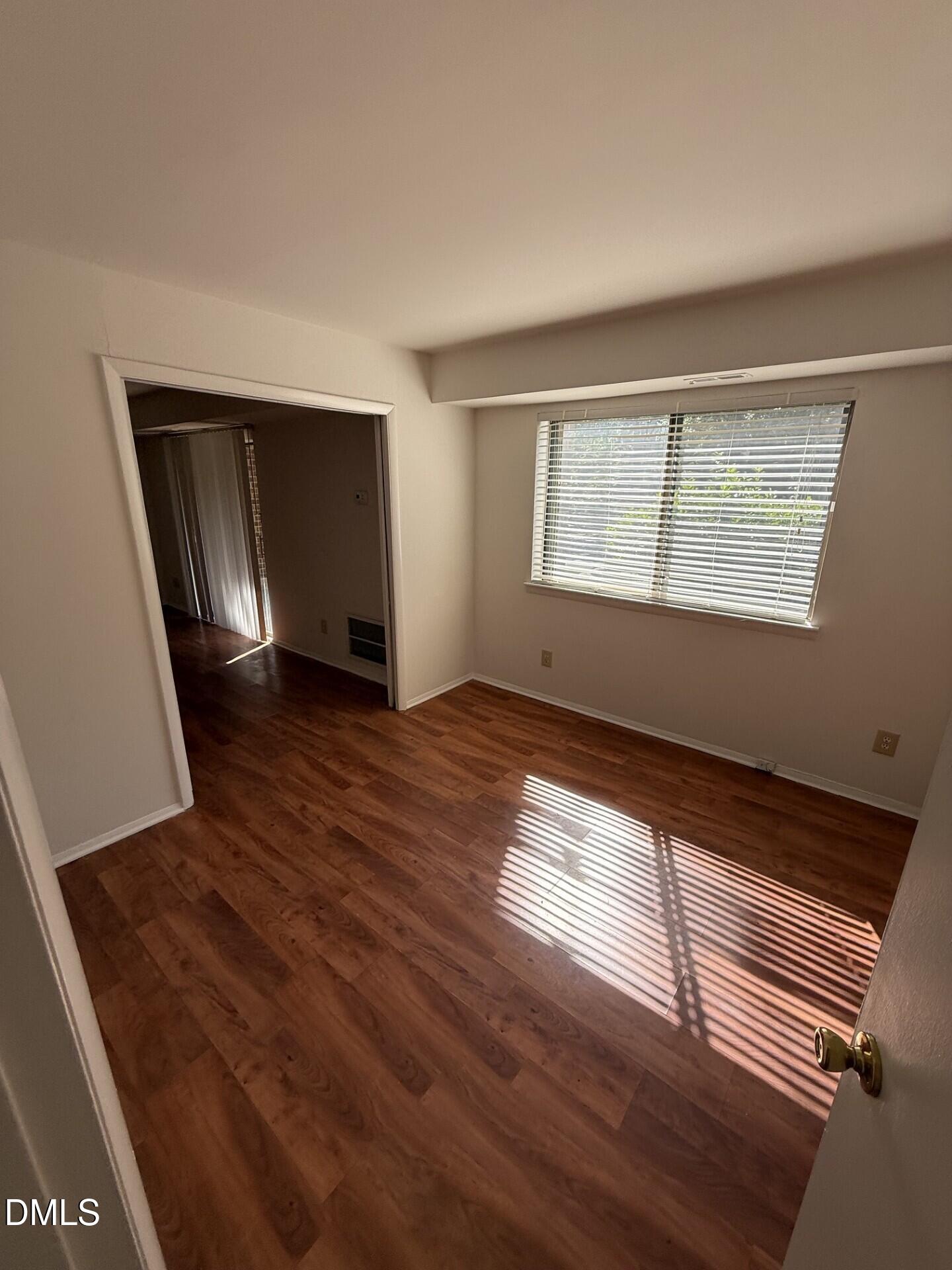 1299 Schaub Drive, Unit D Raleigh, NC 27606 - Photo 8 of 16 an empty room with wooden floor and windows
