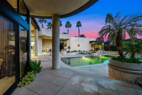 a view of a house with swimming pool and sitting area