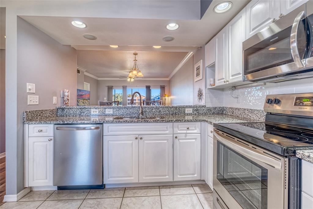960 Starkey Road, Unit 1502 Largo, FL 33771 - Photo 10 of 36 a kitchen with stainless steel appliances granite countertop a stove sink and cabinets