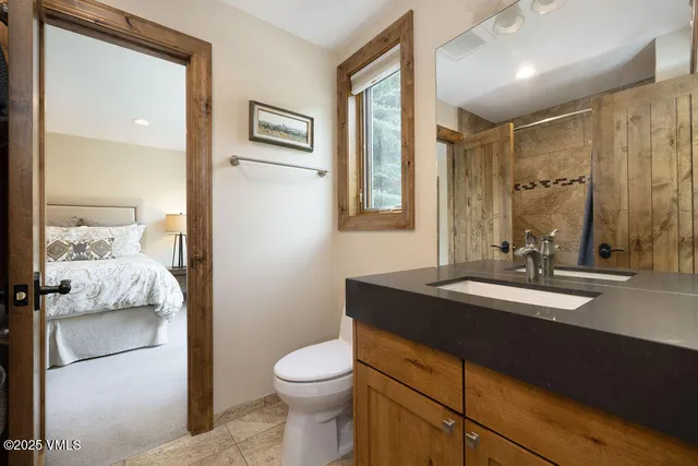 a bathroom with a granite countertop sink toilet and shower