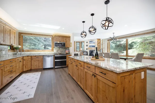 a large kitchen with a window and stainless steel appliances