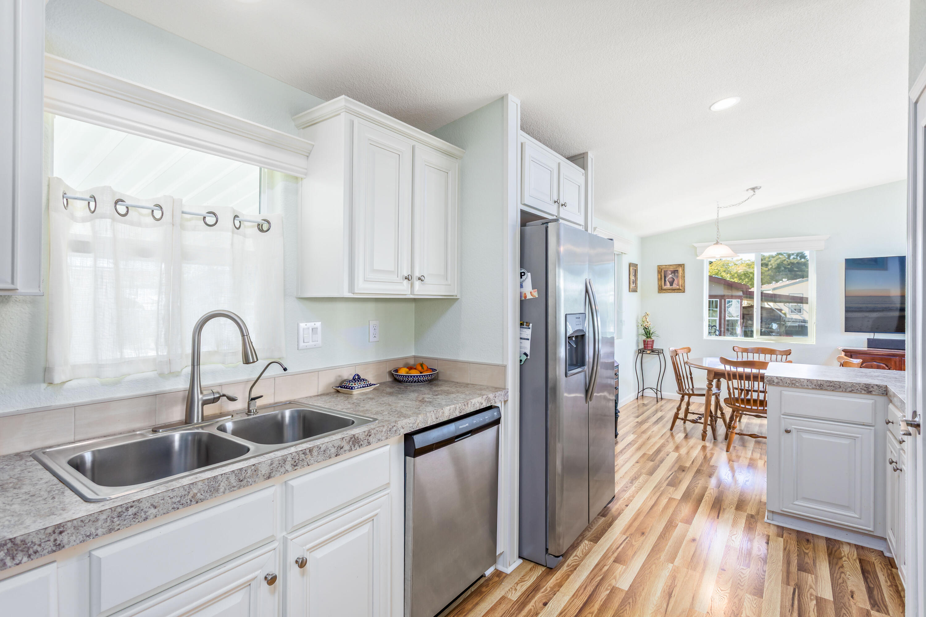 333 Old Mill Road, Unit SPC 66 Santa Barbara, CA 93110 - Photo 10 of 33 a kitchen with stainless steel appliances granite countertop a refrigerator a sink a stove and white cabinets with wooden floor