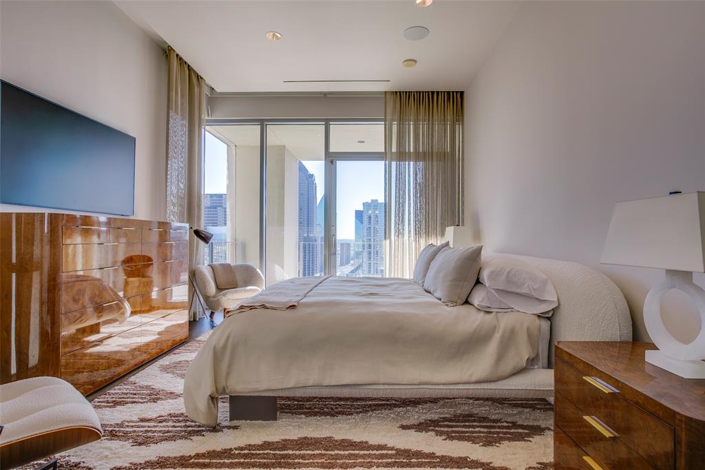 1717 Arts Plaza, Unit 1915 Dallas, TX 75201 - Photo 18 of 31 a large bedroom with a bed and glass door