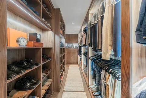 a view of walk in closet with clothes and shoes
