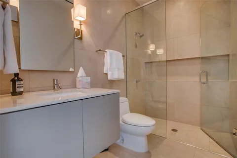 a bathroom with a granite countertop sink a toilet and shower