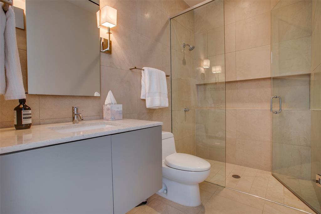 1717 Arts Plaza, Unit 1915 Dallas, TX 75201 - Photo 26 of 31 a bathroom with a granite countertop sink a toilet and shower