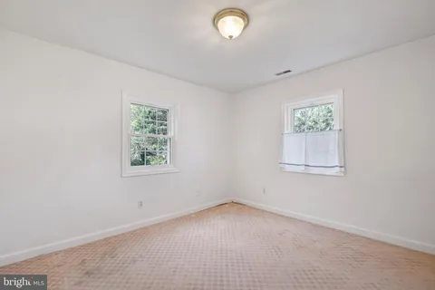 a bedroom with a bed and a dresser next to a window