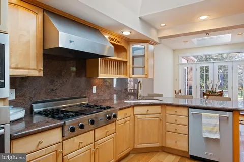 a kitchen with stainless steel appliances granite countertop a stove and a sink