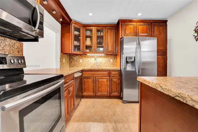 a kitchen with stainless steel appliances granite countertop a stove and a refrigerator
