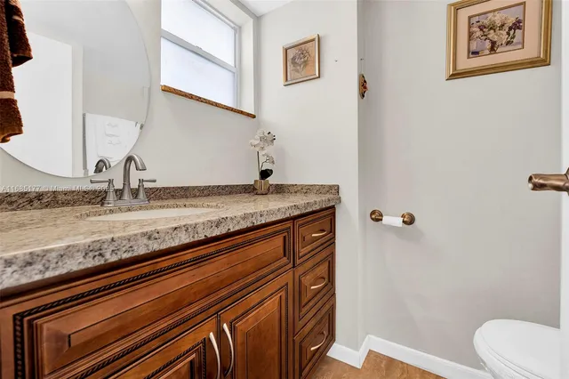 a bathroom with a granite countertop sink and a mirror
