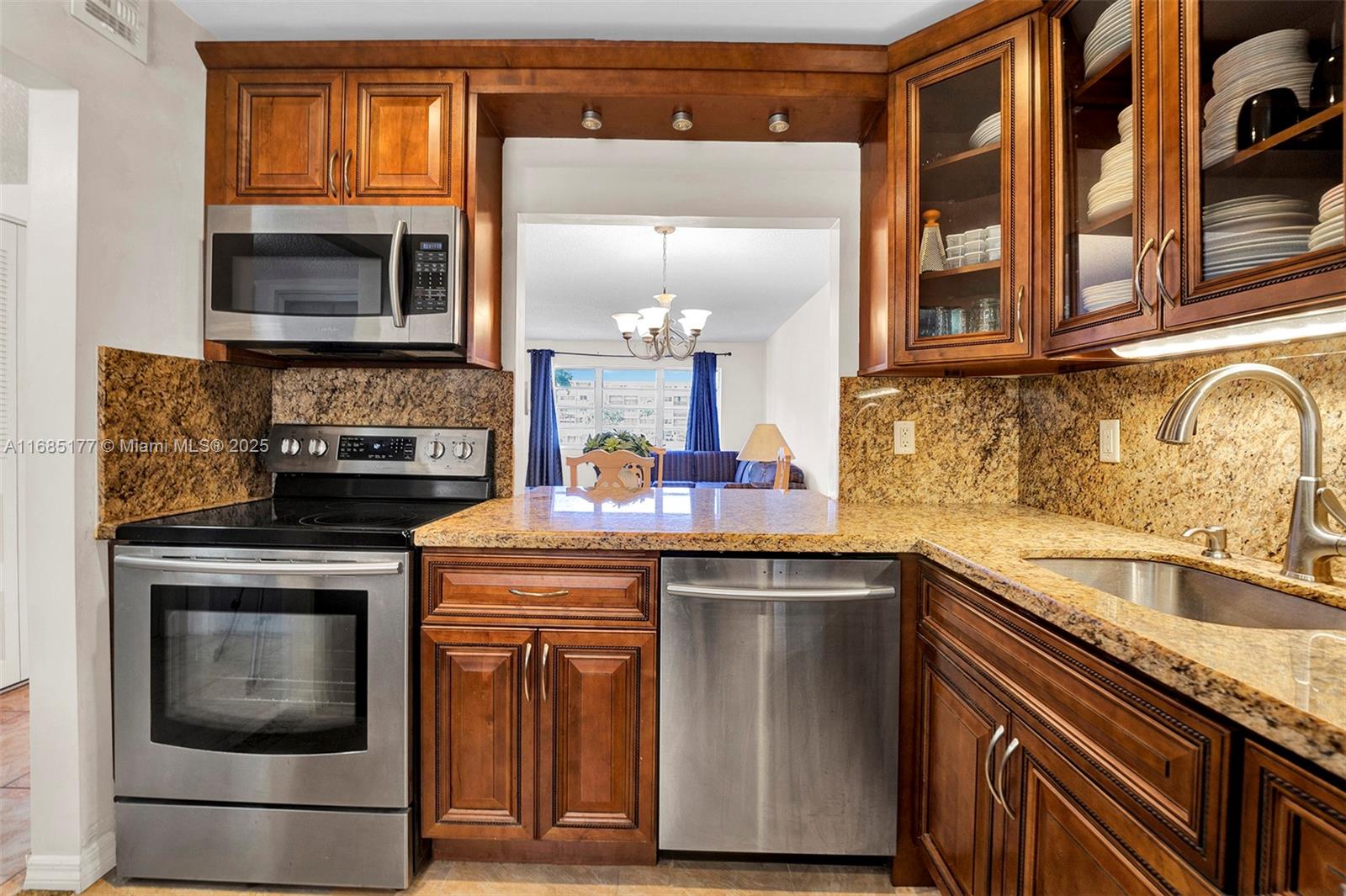 410 Southeast 2nd Street, Unit 220 Hallandale Beach, FL 33009 - Photo 2 of 25 a kitchen with a sink and a microwave