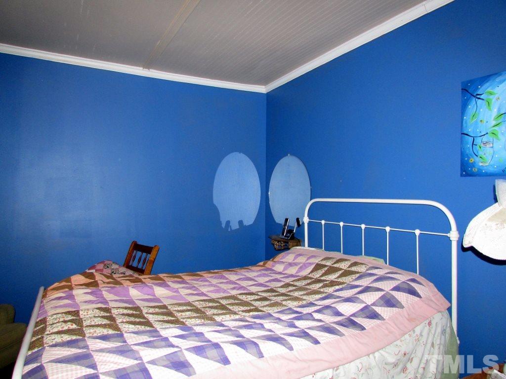 276 Vance Wrenn Road Roxboro, NC 27573 - Photo 4 of 12 a bedroom with a bed and a lamp