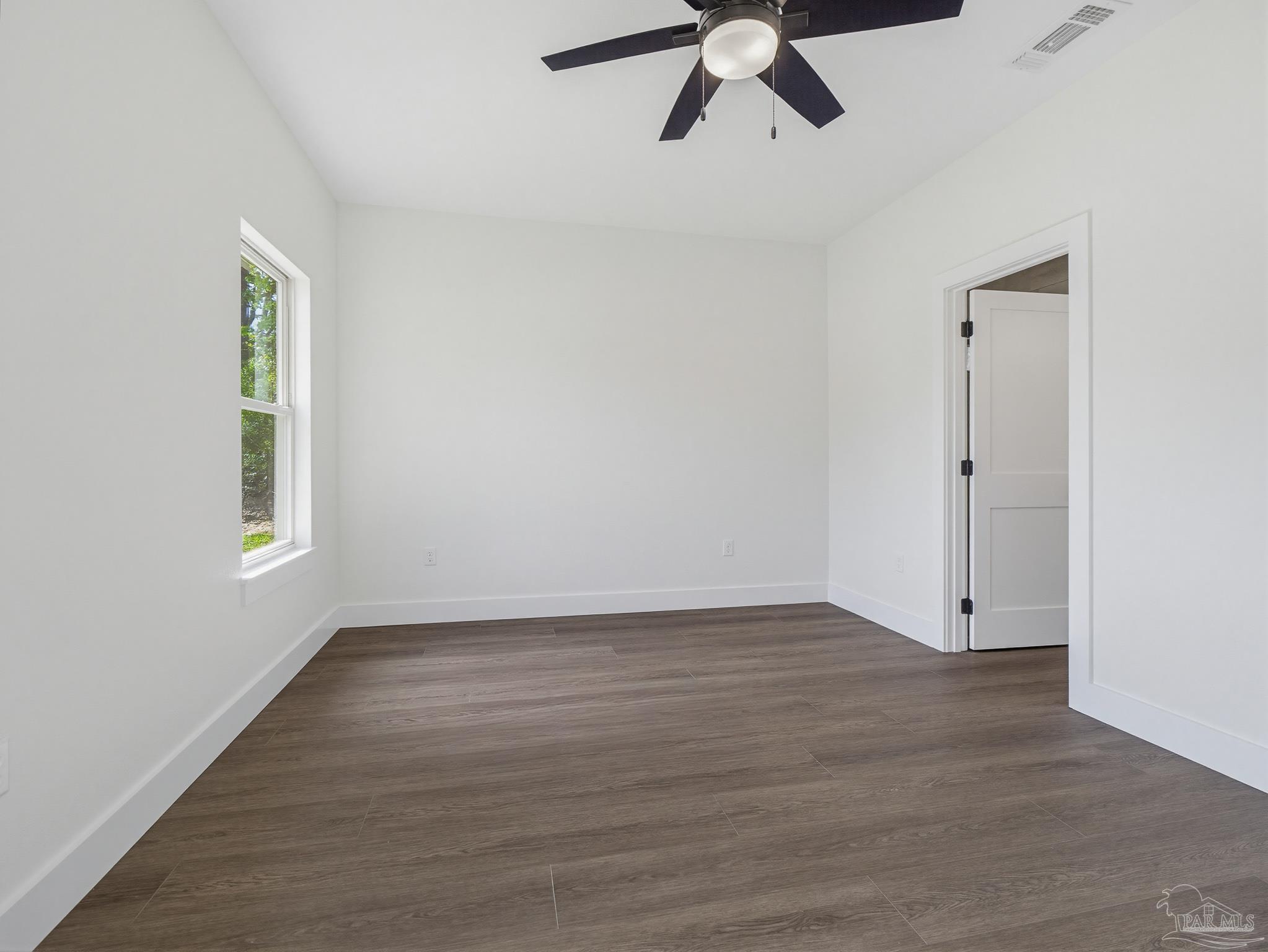 5724 Riviera Drive Milton, FL 32583 - Photo 25 of 52 an empty room with wooden floor fan and windows