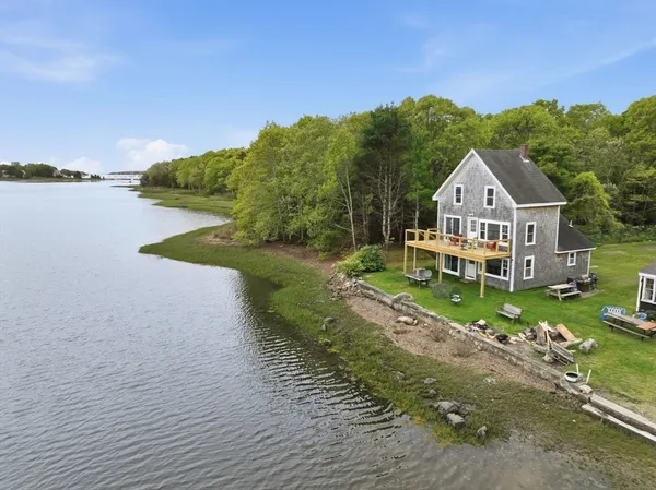 a front view of a house with a yard and lake view
