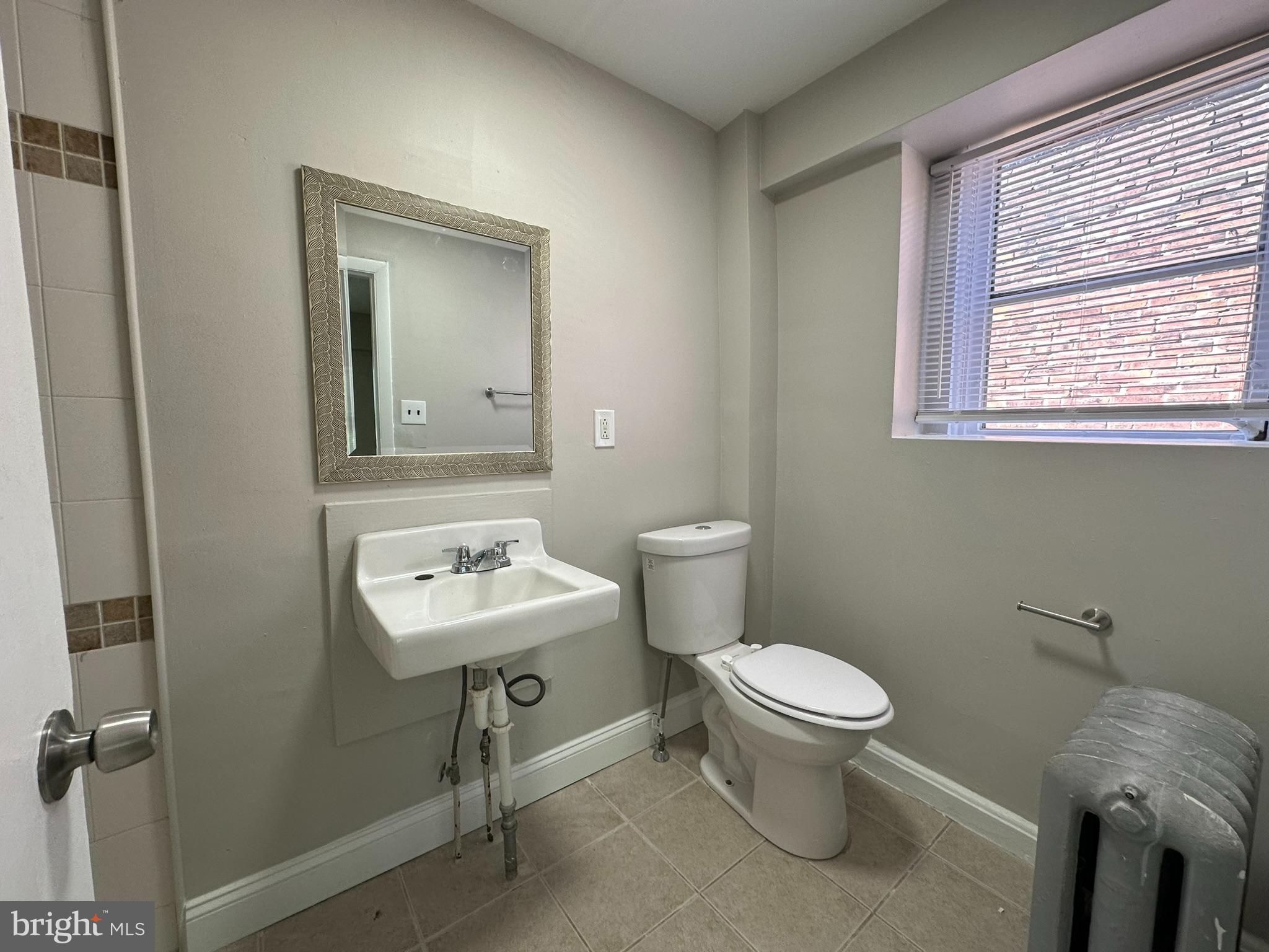 7028 Paschall Avenue Philadelphia, PA 19142 - Photo 19 of 21 a bathroom with a toilet sink and mirror