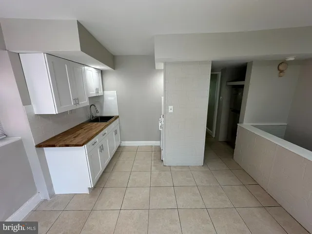 a kitchen with a sink a refrigerator and cabinets