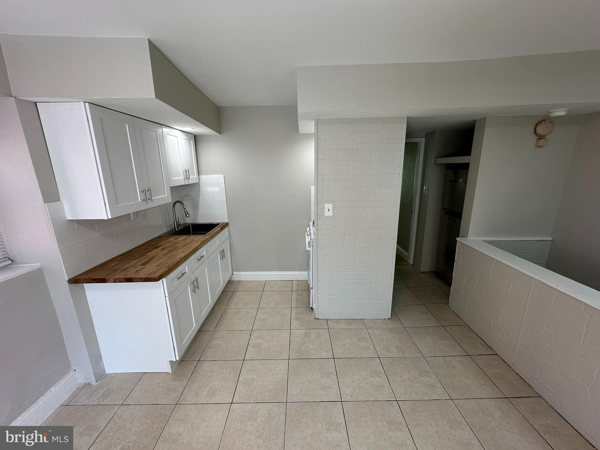 7028 Paschall Avenue Philadelphia, PA 19142 - Photo 8 of 21 a kitchen with a sink a refrigerator and cabinets